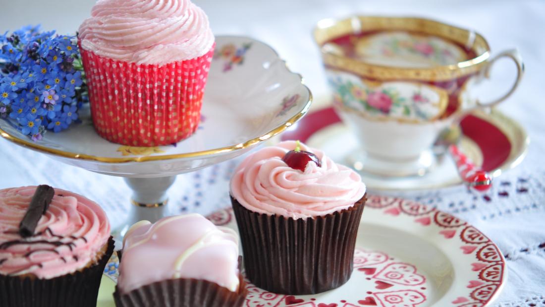 A table of cakes with a mug cup of tea