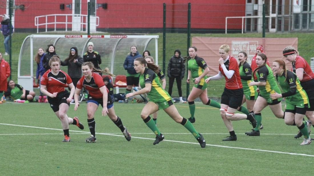 Kate is seen running in the middle of the field, surrounded by players