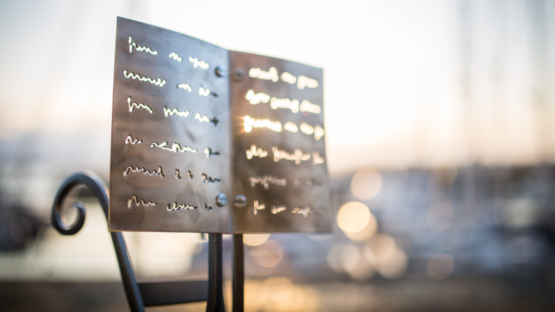 An Award which looks like writing on pages, wrought in metal