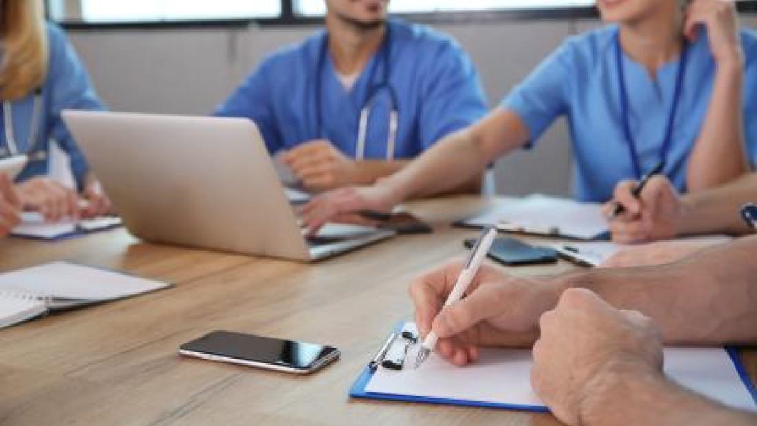 medical professionals sitting around table 