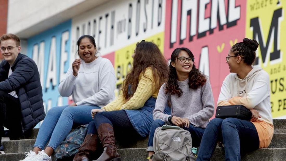 Students sitting on the steps outside Pontio