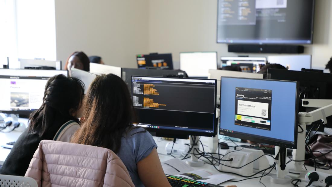 Two students looking at databases in the new trading floor