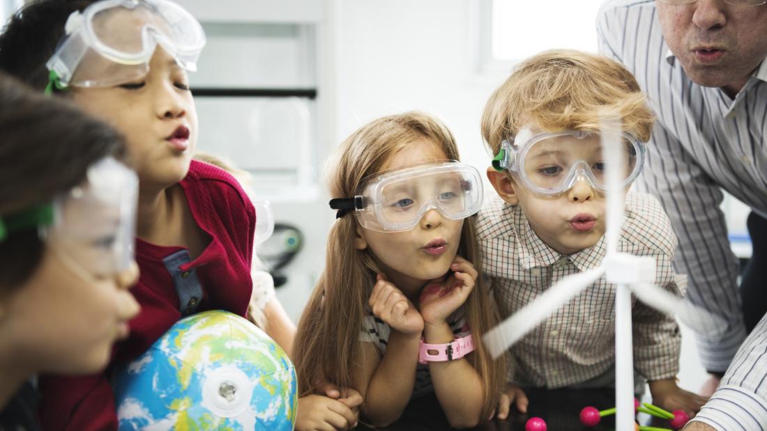 group of children taking part in a demonstration of wind power