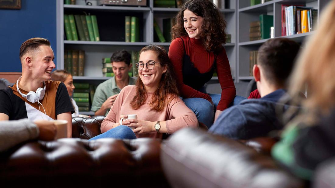 A group of students socialising and relaxing in Barlows at St Mary's Student Village