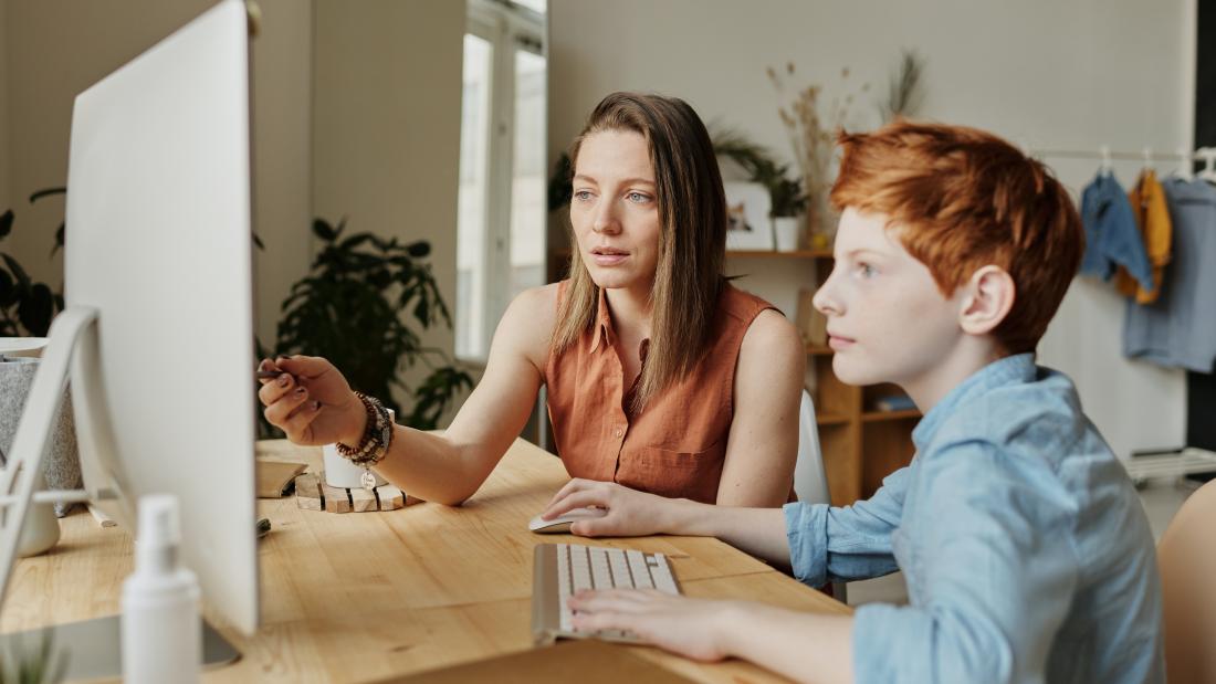 an image of a young teen receiving help from, family member