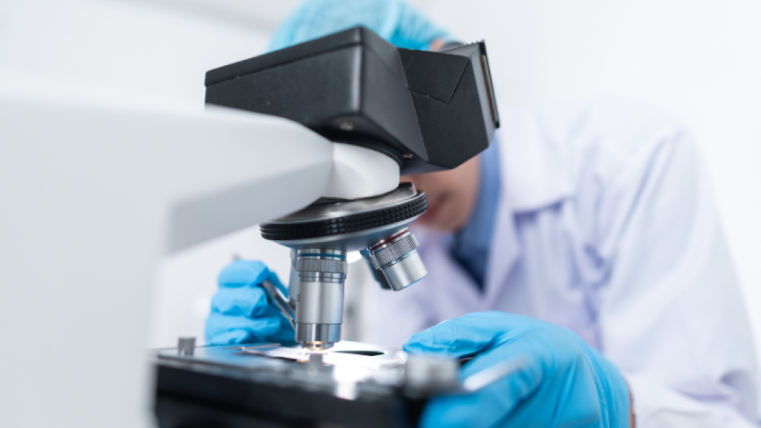 Person working with a microscope in a lab