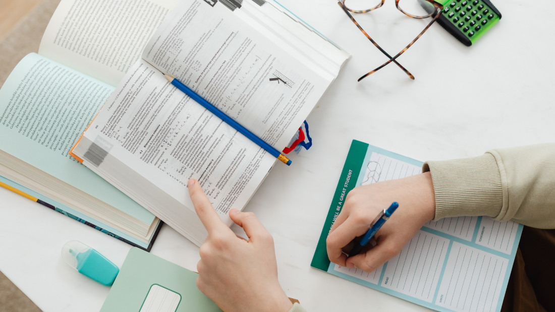Person with books, glasses and calculator