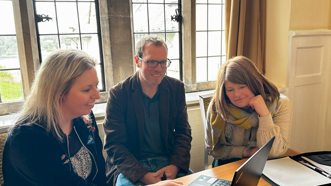 A group clustered around a laptop