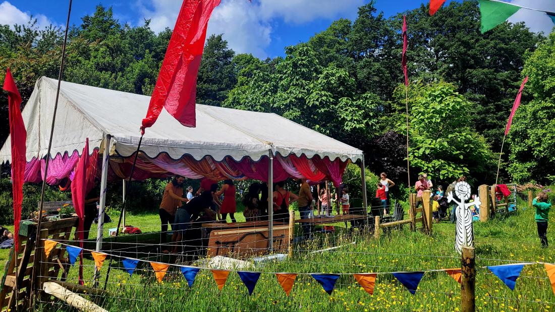 outdoors tent, grass and tree background, people playing games. 