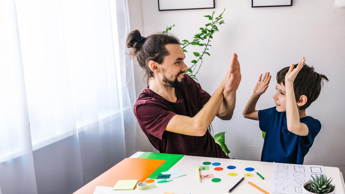 Boy playing learning games with man