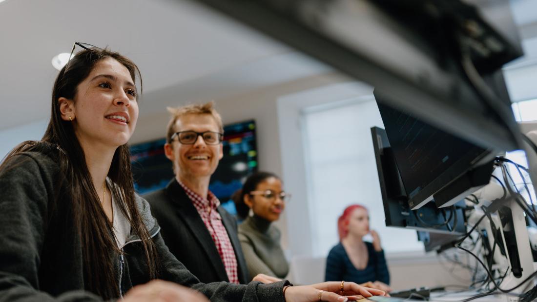 Students looking at computer with lecturer