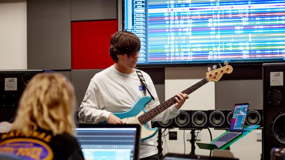 Musician recording the bass guitar in studio