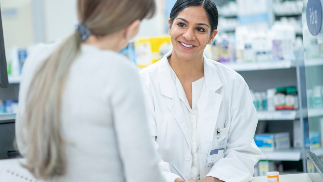 Pharmacist talking to a customer over a counter