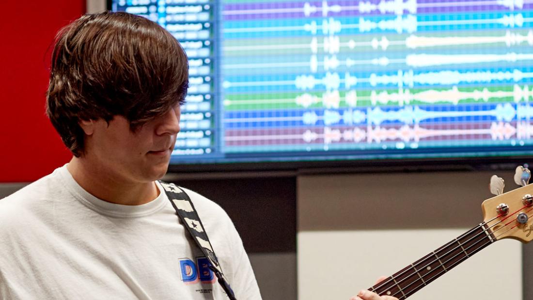 Musician recording the bass guitar in studio