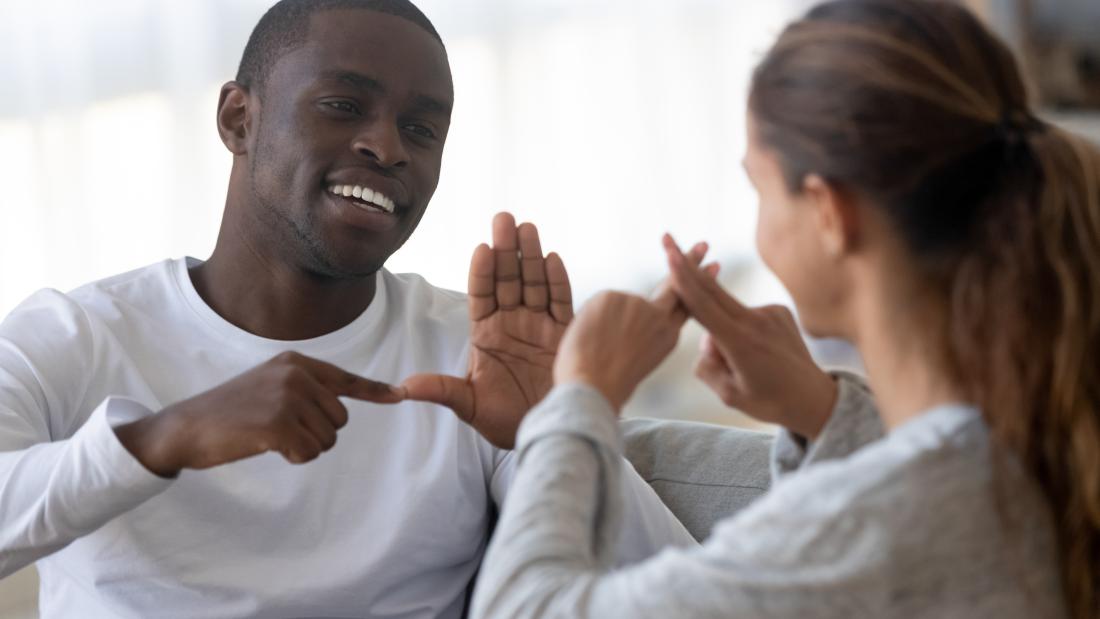 Two people sign to each other