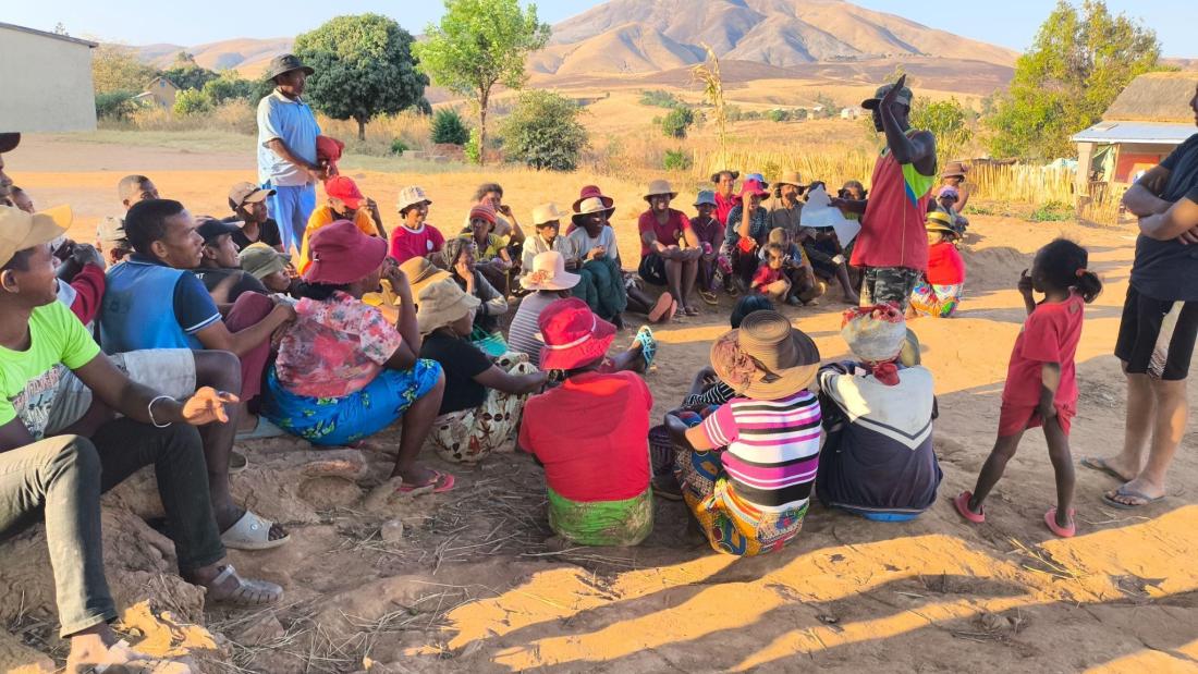 Group of people siting outside in Madagascar discussing 
