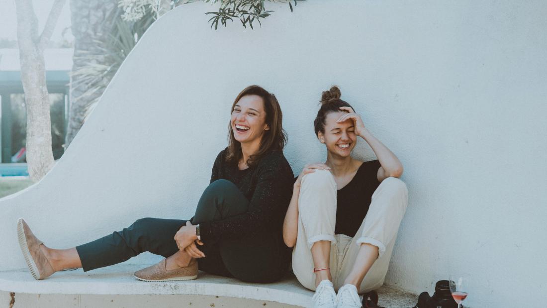 Two women sat together laughing
