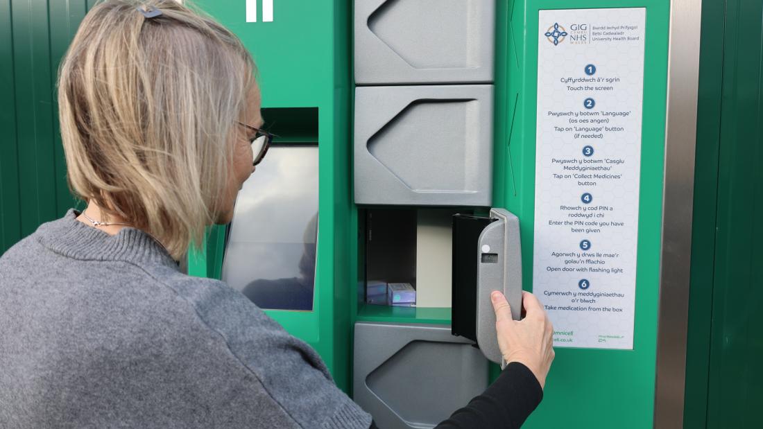 Green box which has doors on to dispense medicine