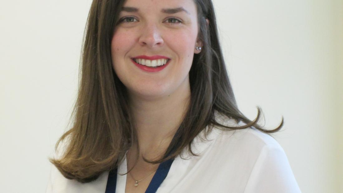 Dr Kat Ford wearing a white blouse, smiling at the camera