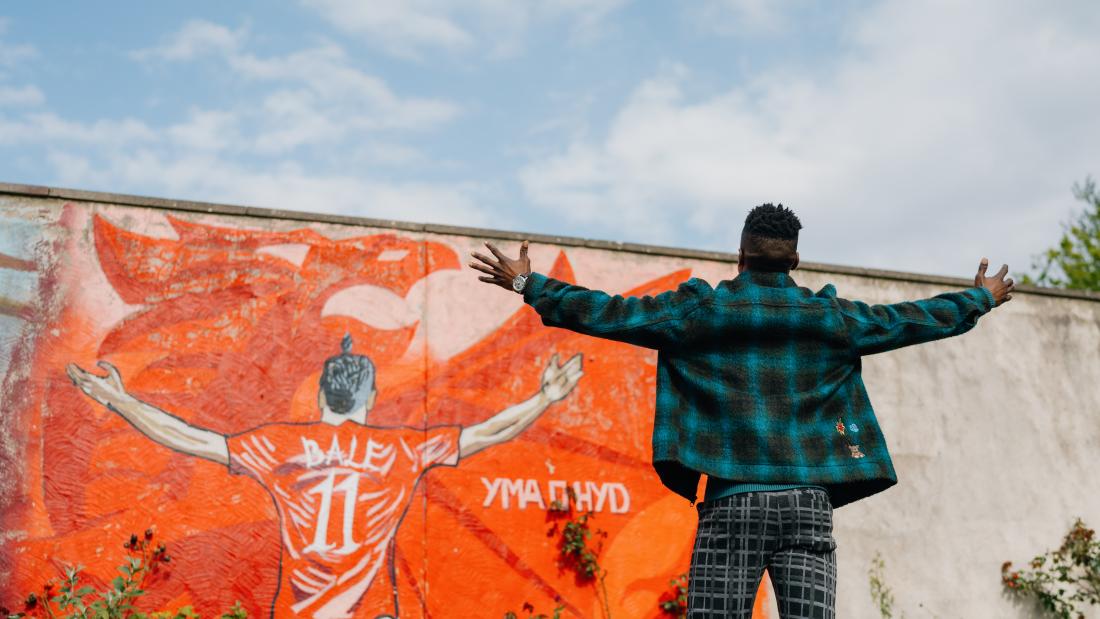 Wales wal graffiti of Gareth Bale and student standing in front