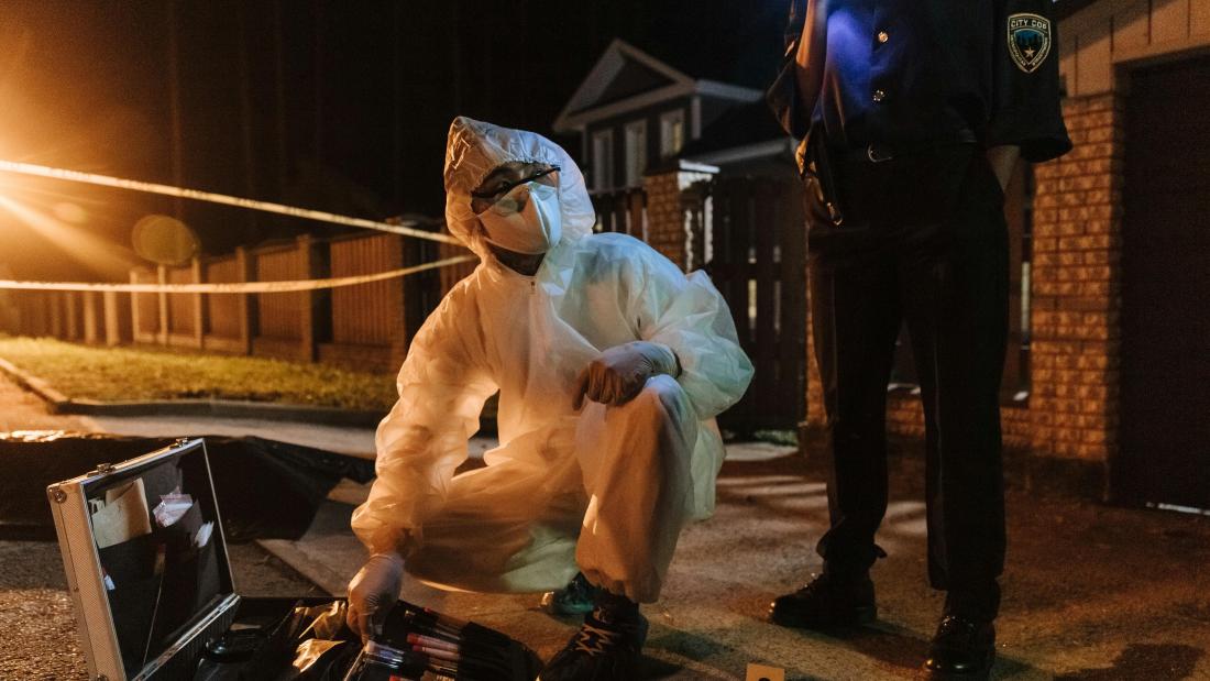 Man in hazmat suit on street at night