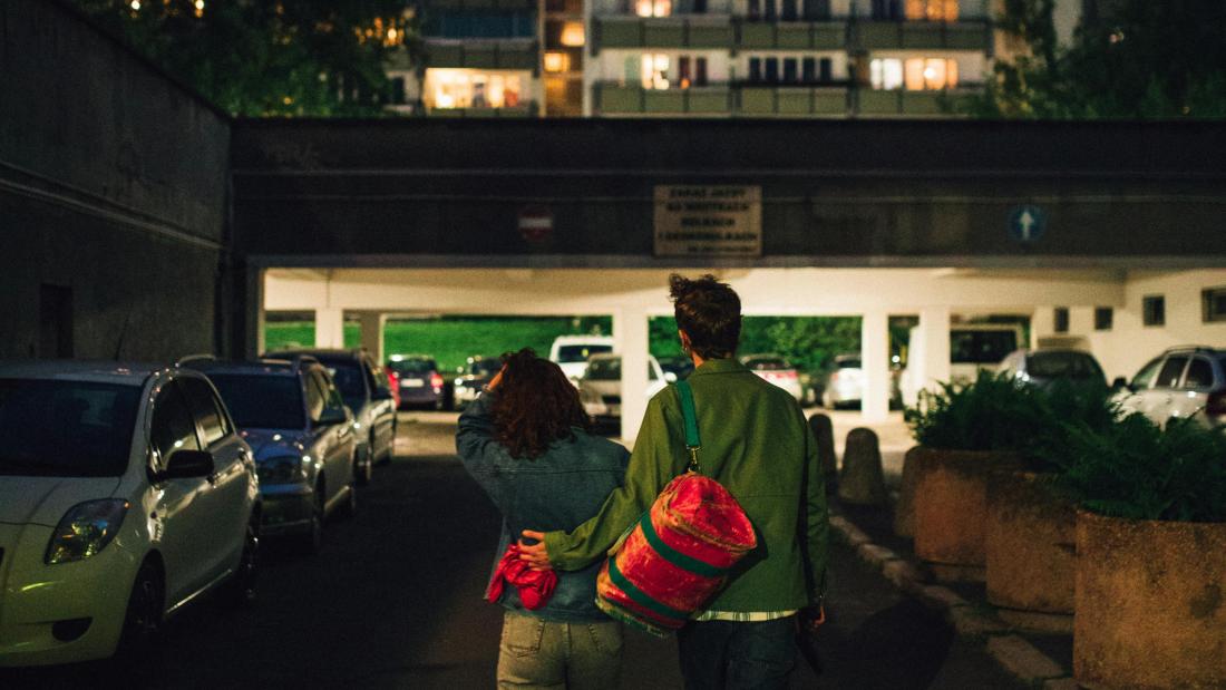 Image of couple walking away towards a car park