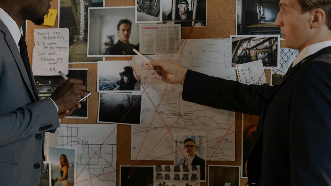 Murder Investigation board with two adults looking at the borad
