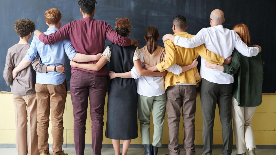 Row of idividuals linking arms facing away from the camera