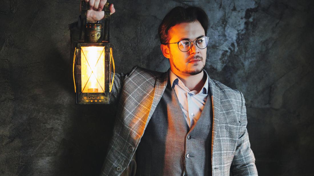 Image of male wearing glasses holding a lamp