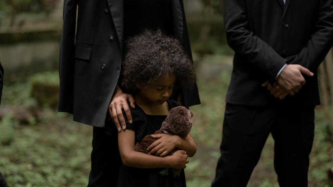 Image of child with a teddy at a funeral