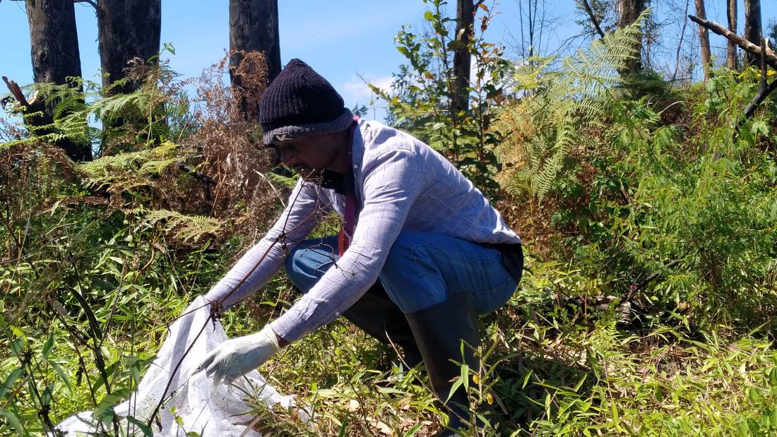 Person kneeling down and lifting a white net