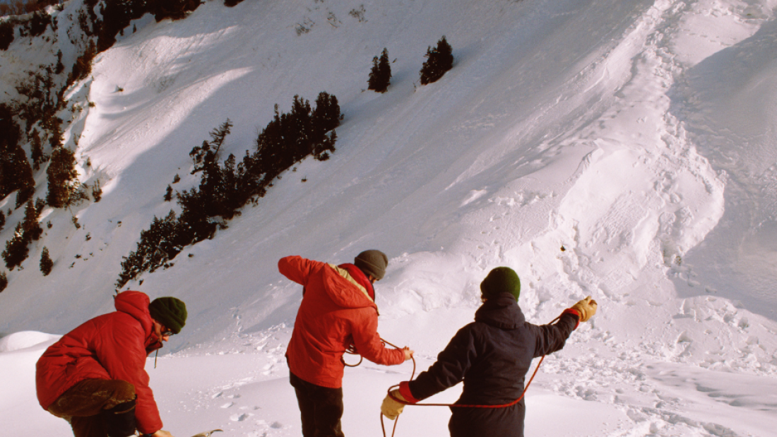 3 climbers on a snowy mountain with climbing gear
