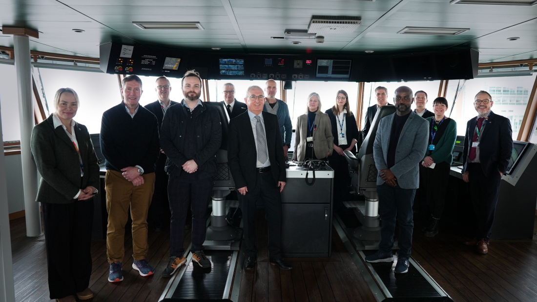 A large group of people standing for a photo aboard a research vessel 