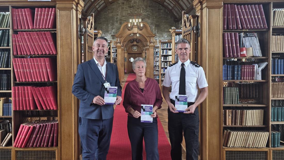North Wales PCC Andy Dunbobbin, Professor Martina Feilzer and Gareth Parry, Optimisation Programme Inspector standing in a library 
