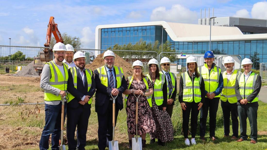 A group photo of people in high-viz to mark work officially beginning on the second building at Bangor University’s Science Park, M-SParc