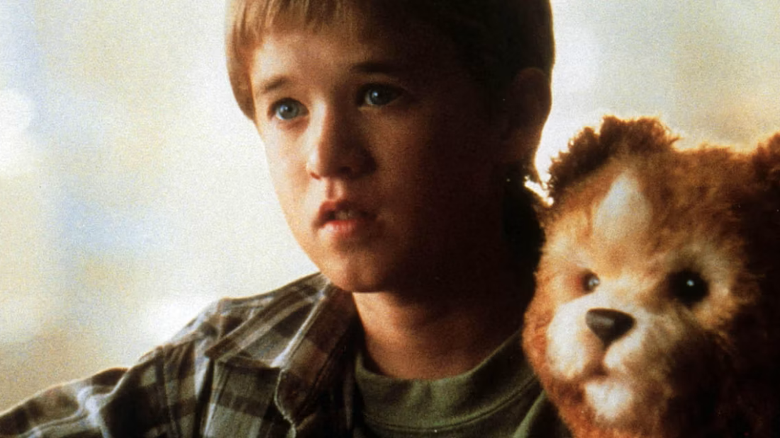 A child with a synthetic robot that looks like a teddy bear