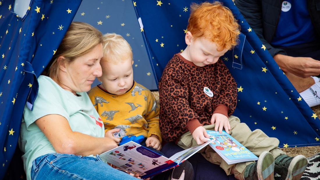 Mother and children reading in a tent