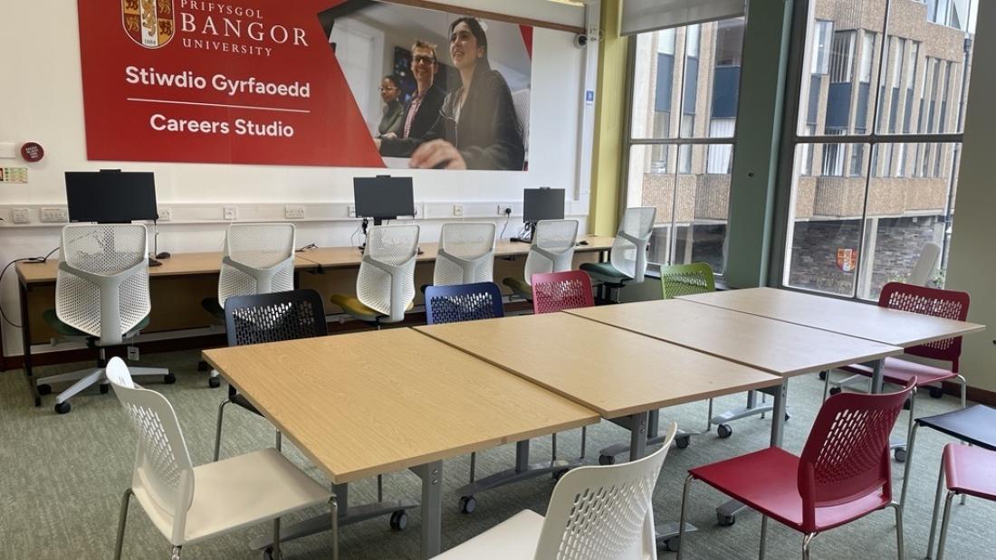 Careers Studio at Bangor University, with computers along one wall and tables and colourful chairs arranged for group work.