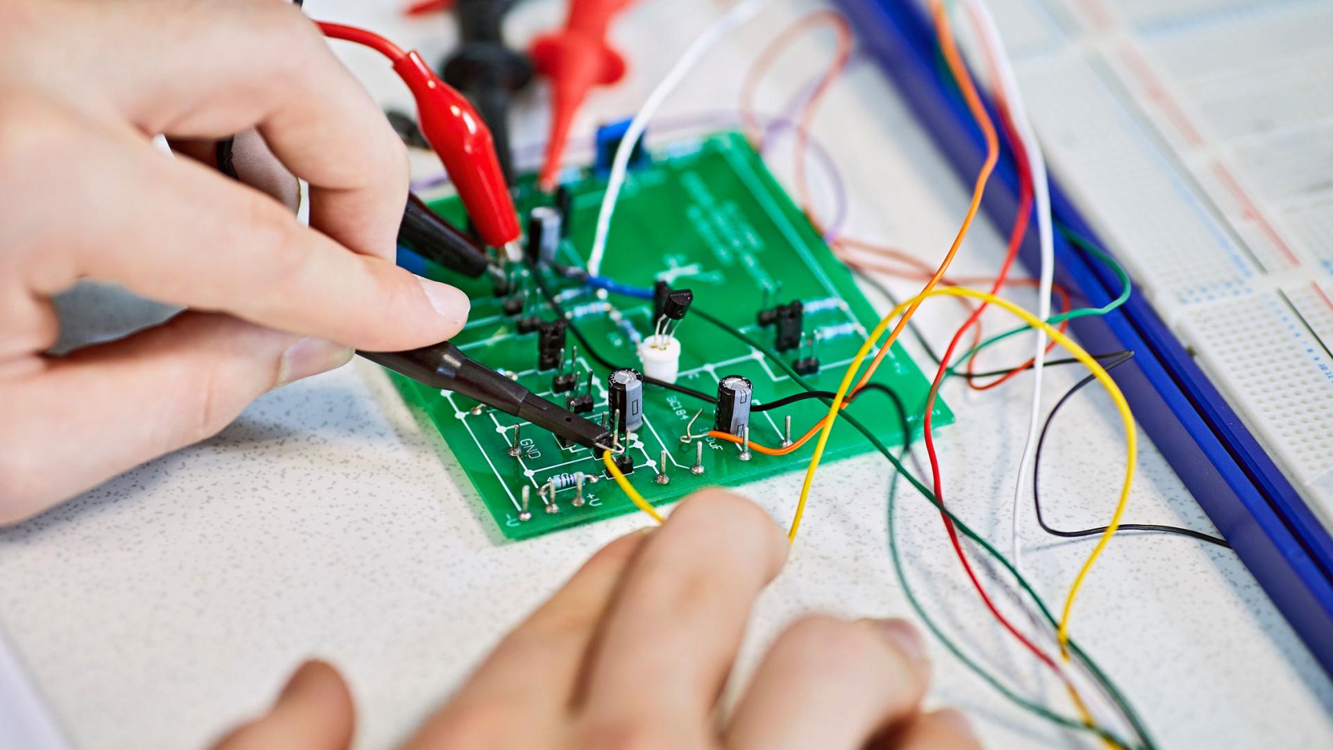 A student using a circuit board in a lab 