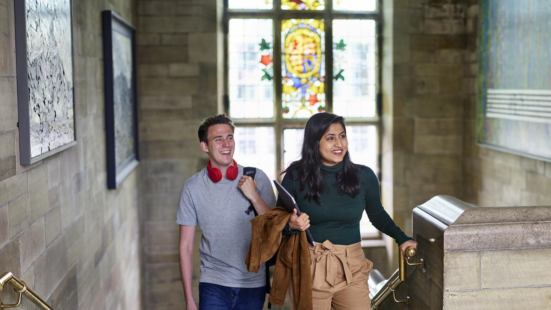 Two students walking up the steps in the Main Arts building