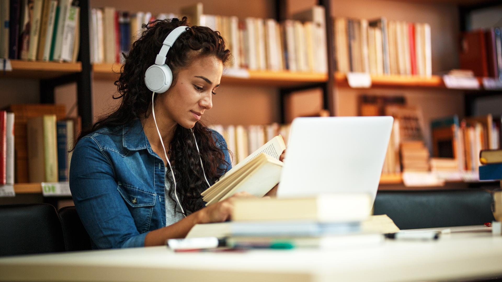 A female student reading and studying in the library