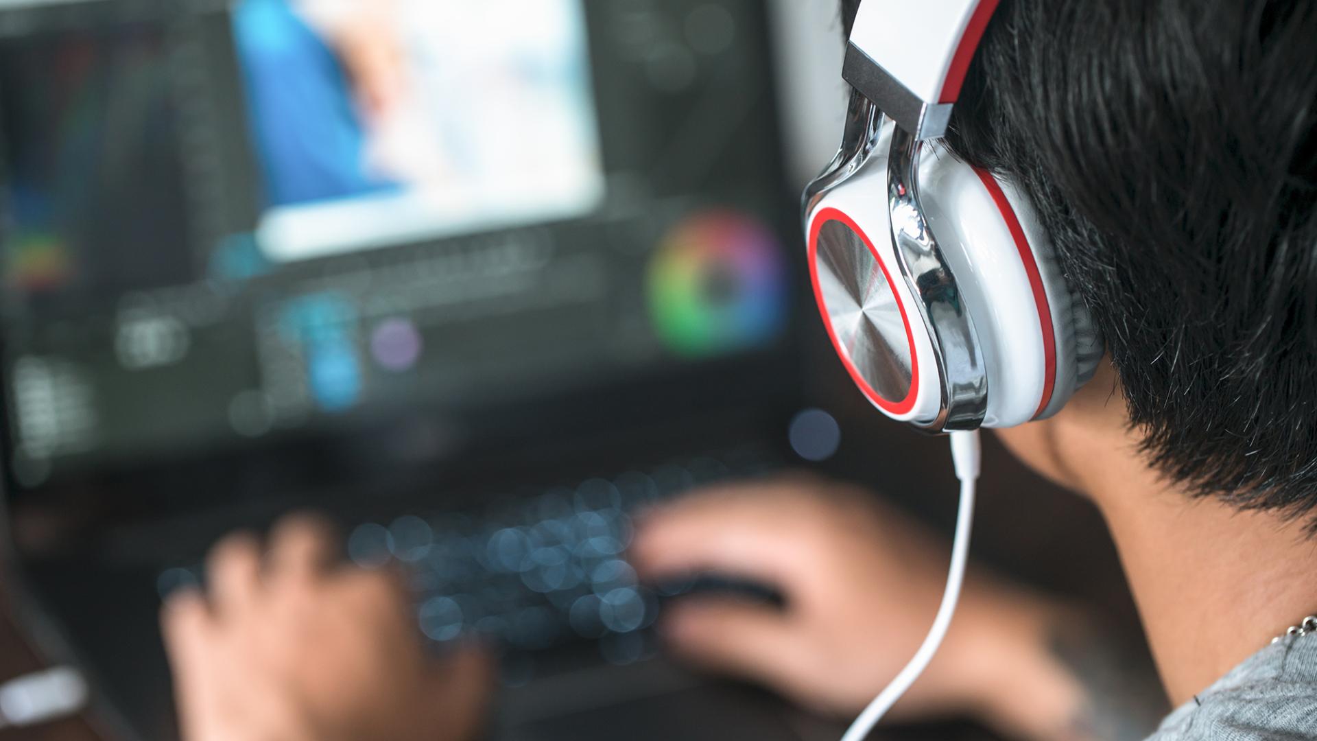 student wearing headphones editing media