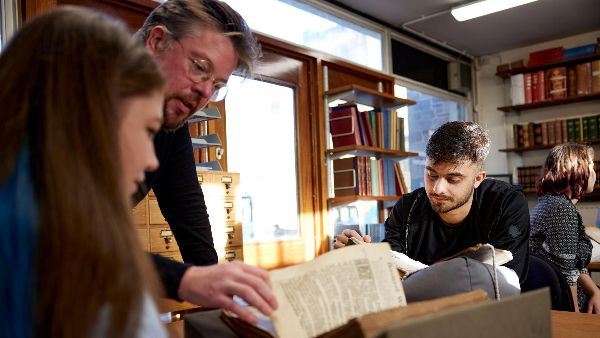 Lecturer reading a book with a student