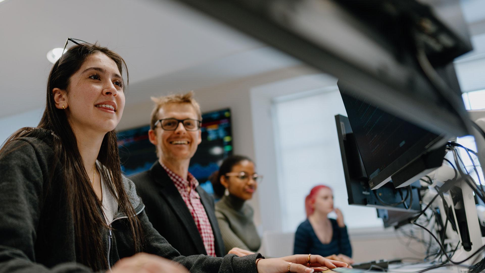 Students looking at computer with lecturer