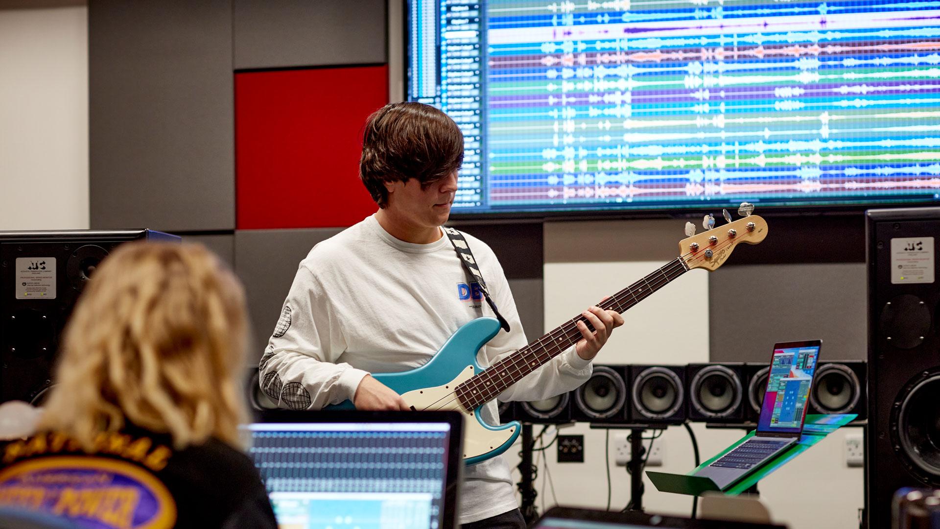 Musician recording the bass guitar in studio