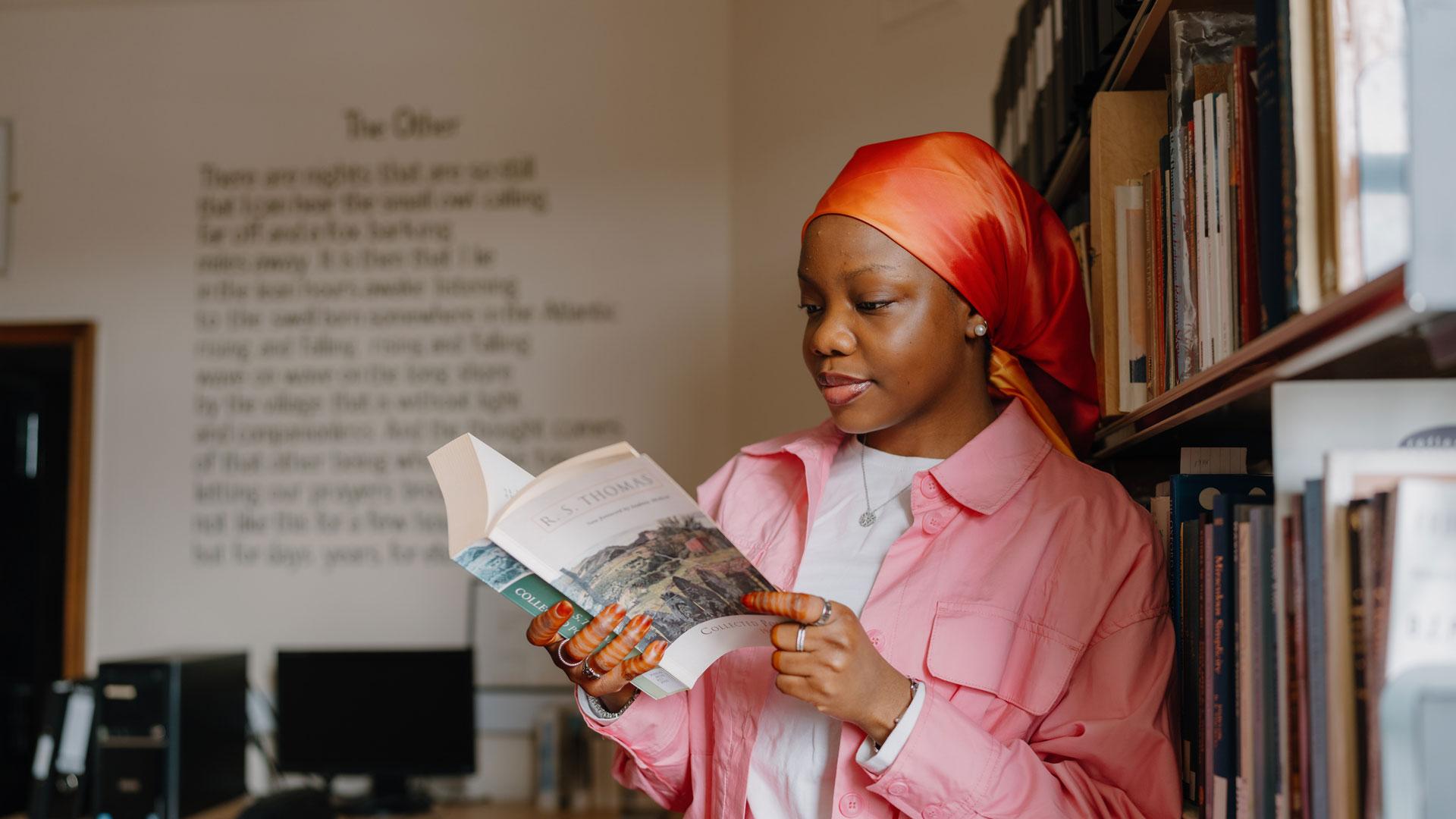 Student reading a poetry book in the library