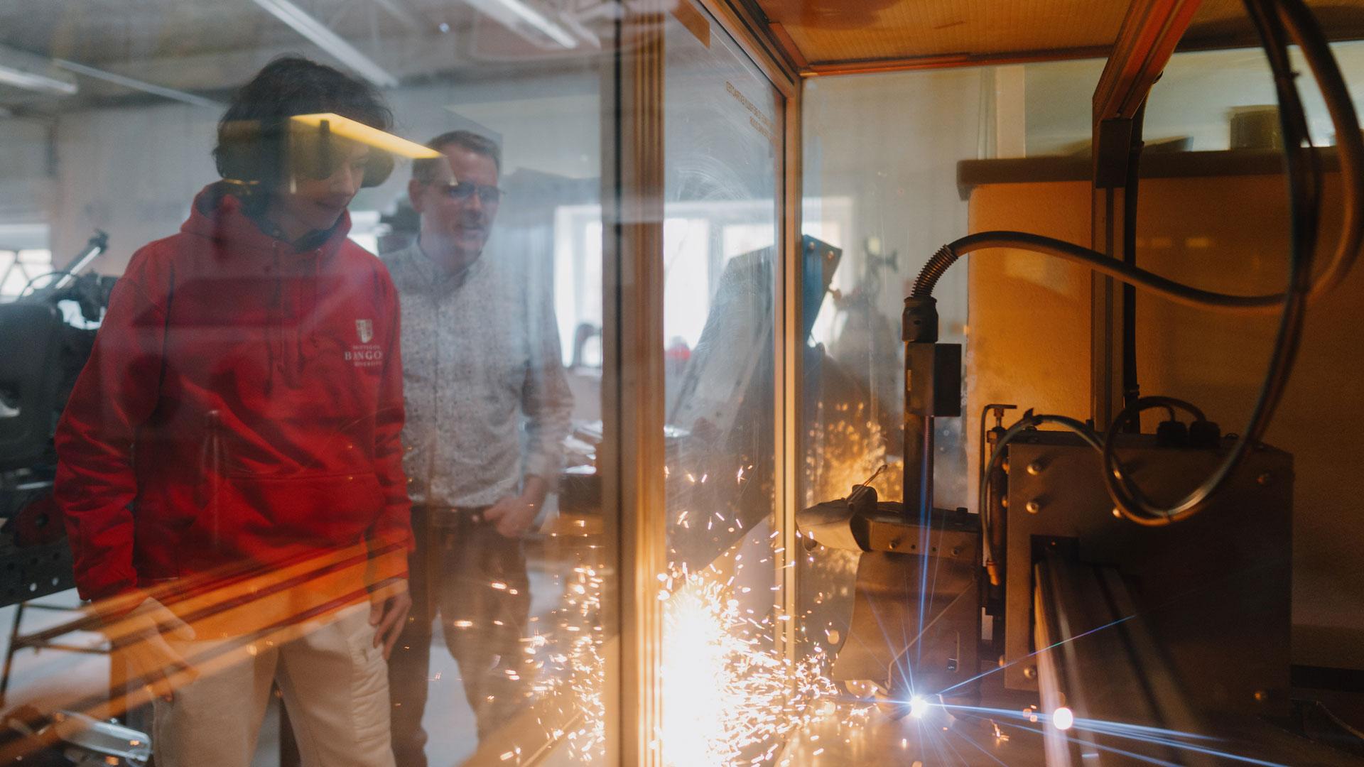 Myfywyr yn gwylio torrwr laser