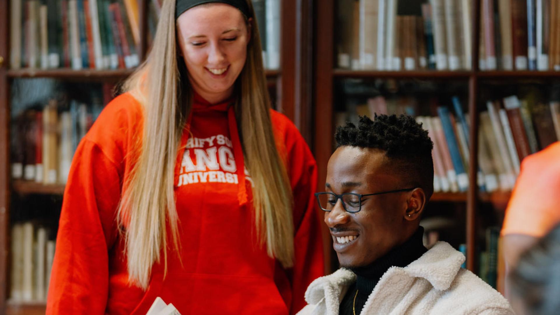 student in library reading Welsh history book