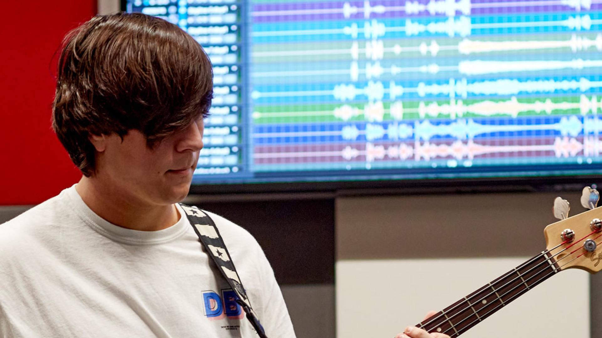 Musician recording the bass guitar in studio