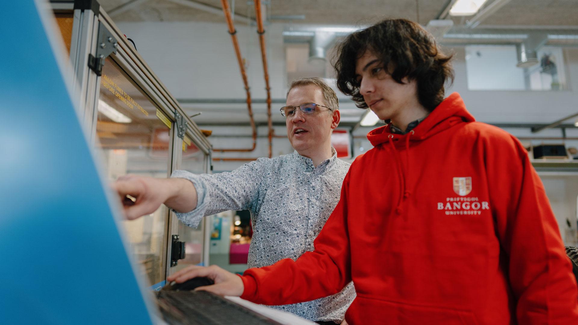 Engineering student with lecturer in a lab